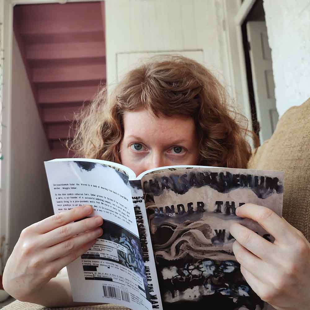 copyright Maggie Umber maggie umber reading a copy of Chrysanthemum Under the Waves by Maggie Umber