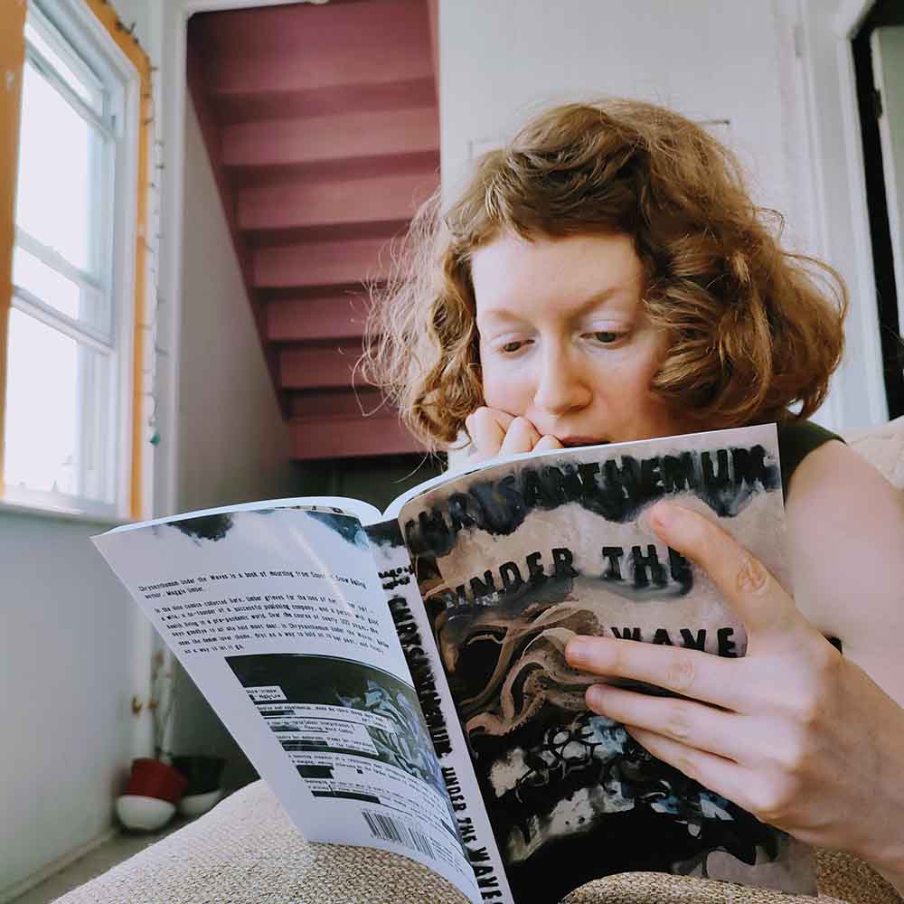 copyright Maggie Umber maggie umber reading a copy of Chrysanthemum Under the Waves by Maggie Umber